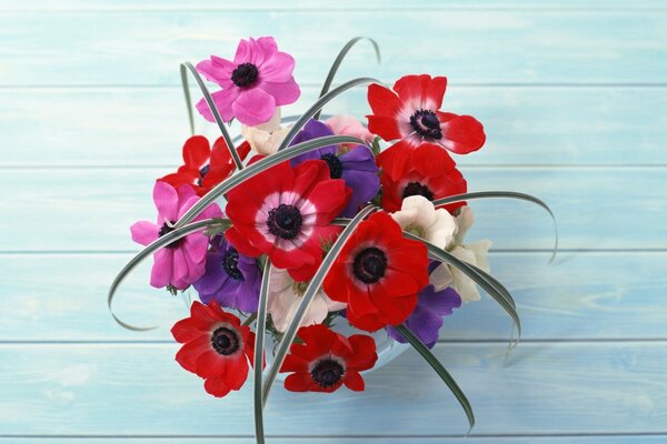 A bouquet of flowers in a pot and on a blue table