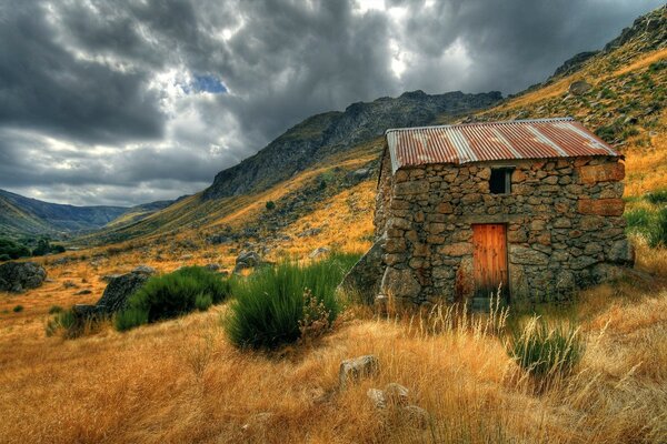 Antiga casa de pedra na encosta da montanha