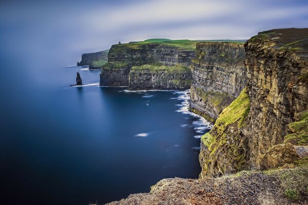 Rock coast green grass sea