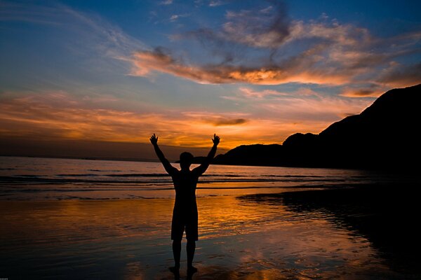 Mann bei Sonnenuntergang am Strand