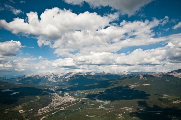 Paisaje de dalina verde desde las alturas de las montañas cubiertas de nieve