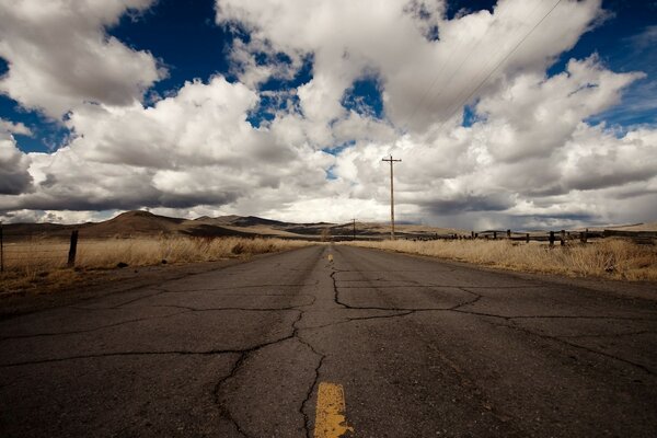 An abandoned lonely highway among dried-up fields