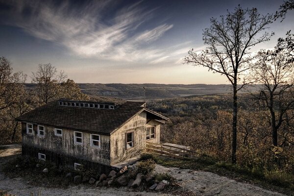 Imagen de una casa abandonada en un acantilado de piedras muchos árboles