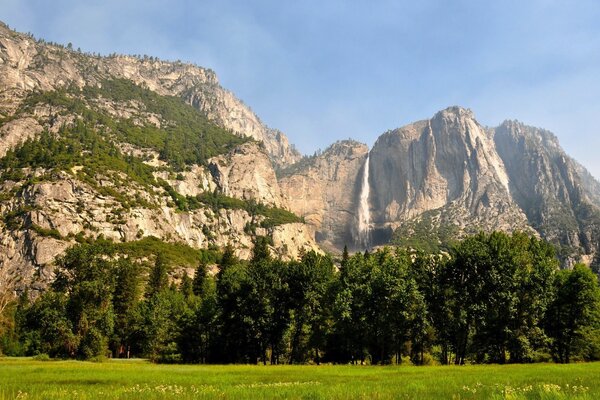 Mountains and a small waterfall descends from the slope