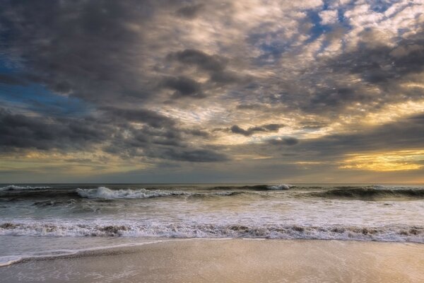 Plage de sable avec la mer avant la tempête