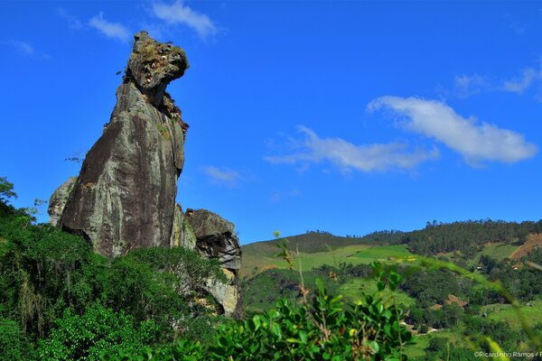 A rocky figure in the shape of a zebra s head in a hilly area