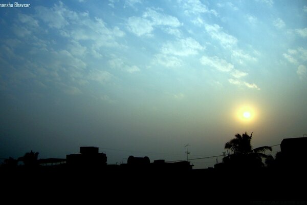 The setting sun over the silhouettes of houses