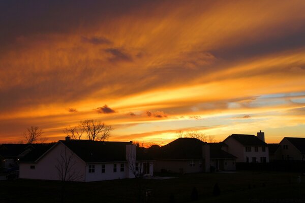 Sunset on the whole sky on the background of houses