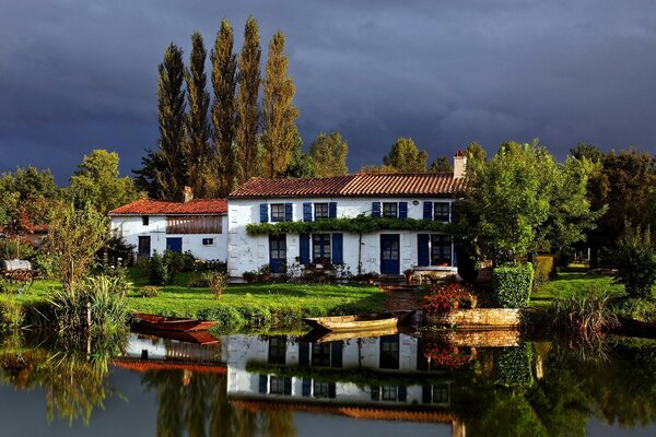 Maison de deux étages sur un lac entouré d arbres