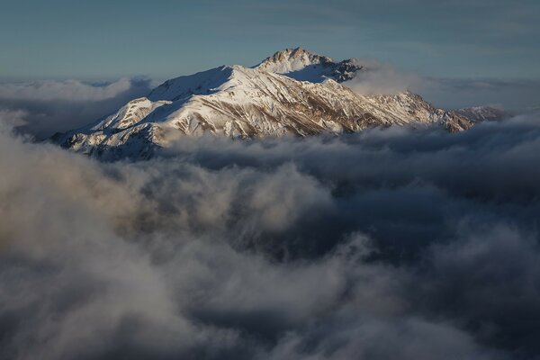 Nuvens envolvendo montanhas de neve