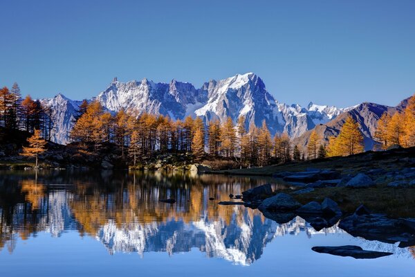 The sky and mountains are reflected in the lake