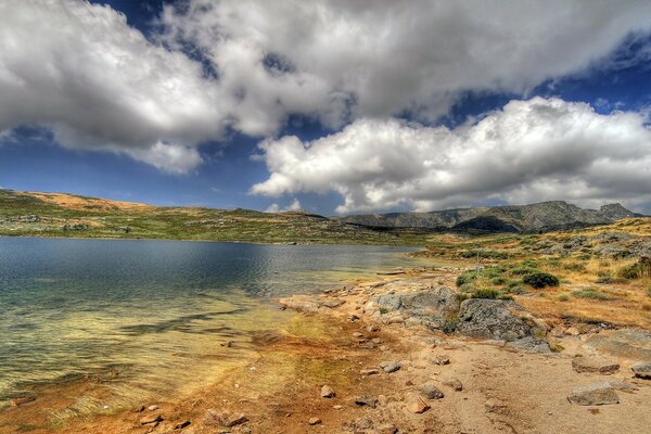 Paysage vallonné avec lac sous le ciel