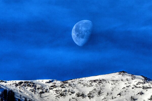 Lune sur fond de montagnes enneigées