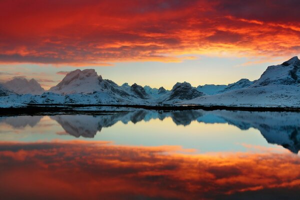 Blutiger Sonnenuntergang über einem Bergsee