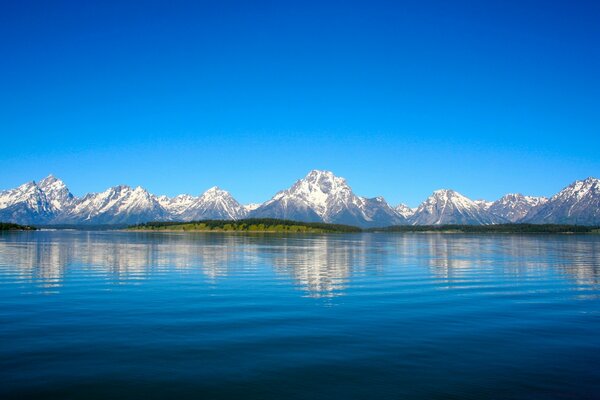 Reflection of snowy mountains in the water surface