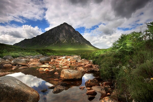 Paysage de rivière avec des pierres près de la montagne