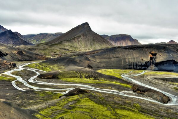 A winding river flowing through green hills