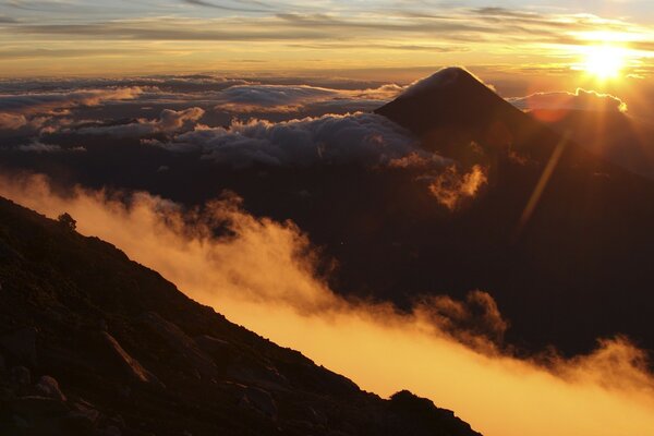 The rising sun above the clouds in the mountains