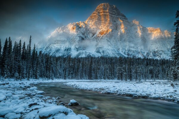 Winter landscape. The river covered with darkness