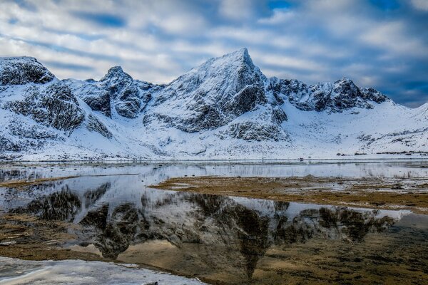 Schneebedeckte Berge spiegeln sich im Wasser des Sees wider