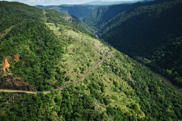 Una strada che attraversa alte colline verdi