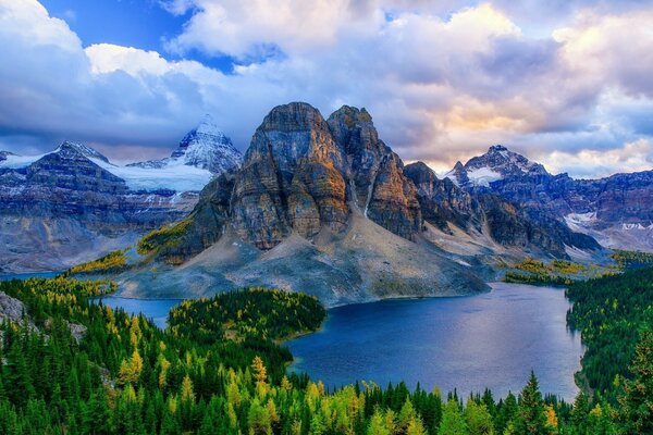 Lago azul rodeado de bosques y montañas bajo un cielo nublado