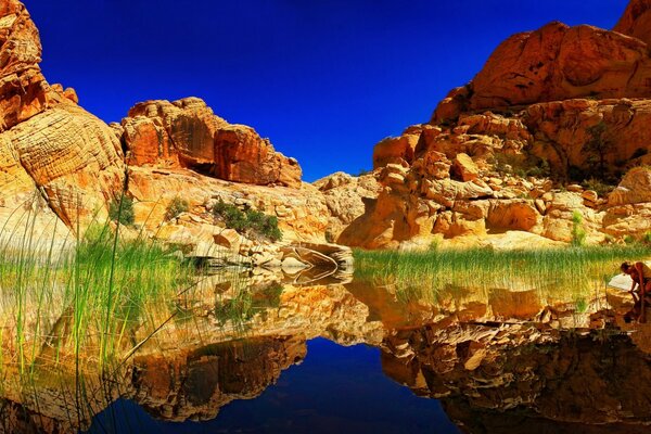 Penhascos de montanha em reflexo do lago