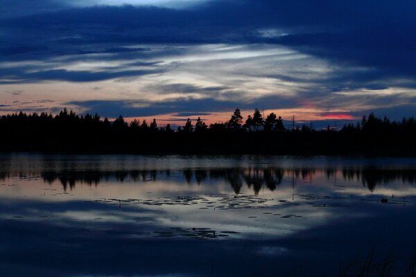 Puesta de sol oscura a orillas de un lago tranquilo