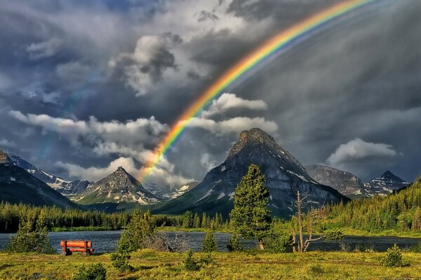 Regenbogen auf dem Hintergrund der blauen Berge