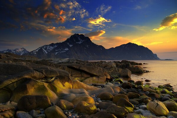 The stone shore, the last rays of the setting sun on the water