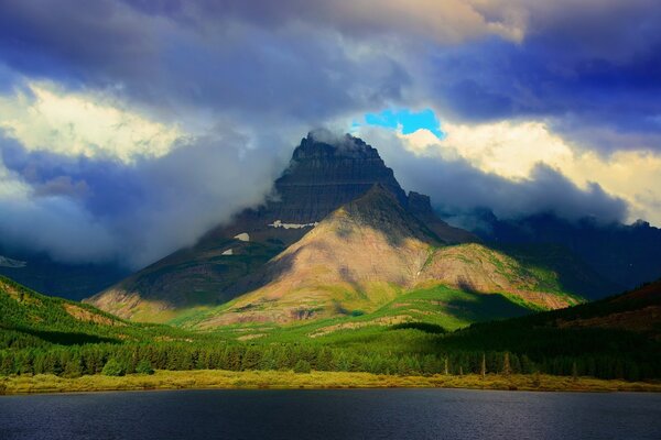 Mountains among clouds on the lake shore