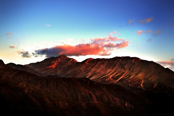 Pink cloud in the blue sky in the mountains