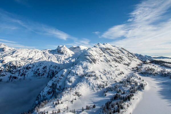 Mountain peaks in snow against a blue sky background