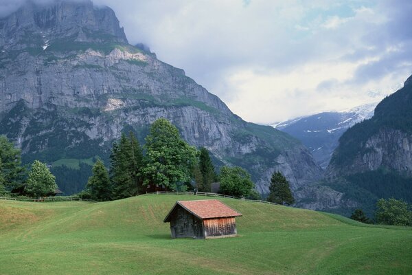 Casa en un claro verde. Montaña