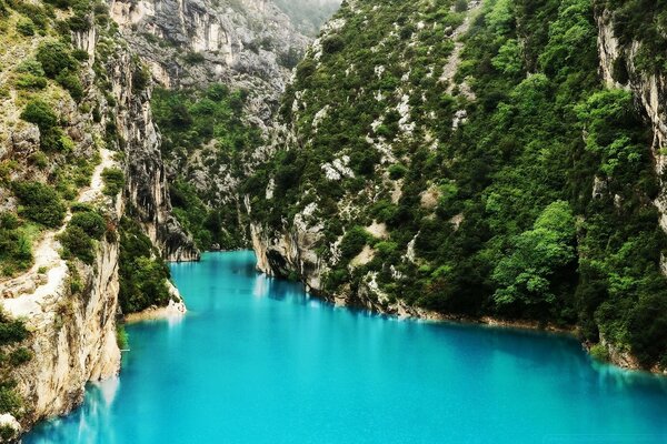 Turquoise water among green rocks