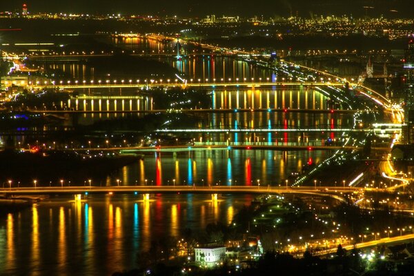 O movimento da cidade noturna e do rio sob as luzes