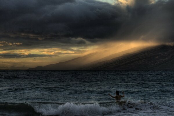 Man surrendered to the elements of the evening sea