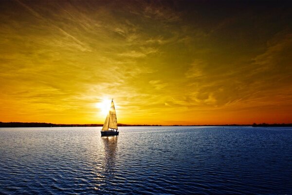 Navire flottant sur la mer au coucher du soleil