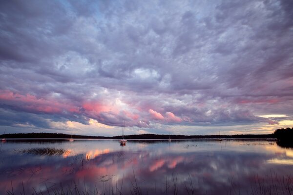 Spiegelreflexion der rosa-violetten Wolken im Wasser