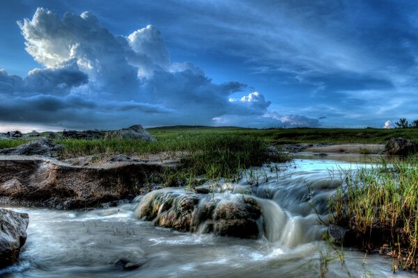 Streams of water running down the rocks against a cloudy sky