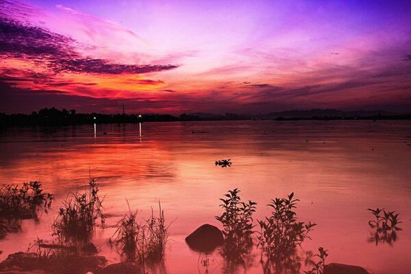 Coucher de soleil sur la rivière large. Dans le ciel des Cirrus multicolores