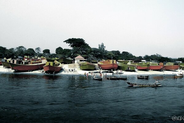 A row of large boats along the river bank