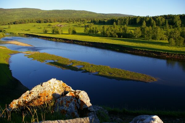 Blauer Teich auf dem Hintergrund des grünen Waldes