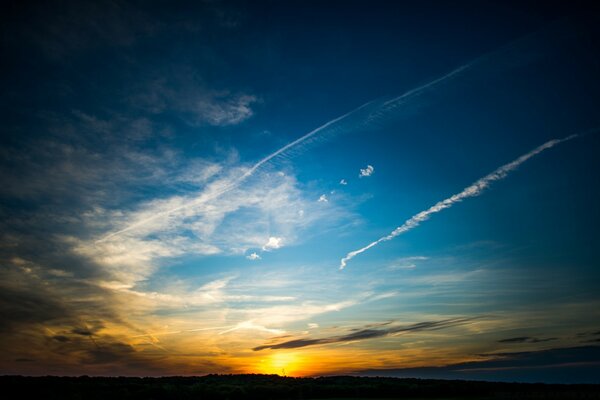 Spur eines fliegenden Flugzeugs bei Sonnenuntergang