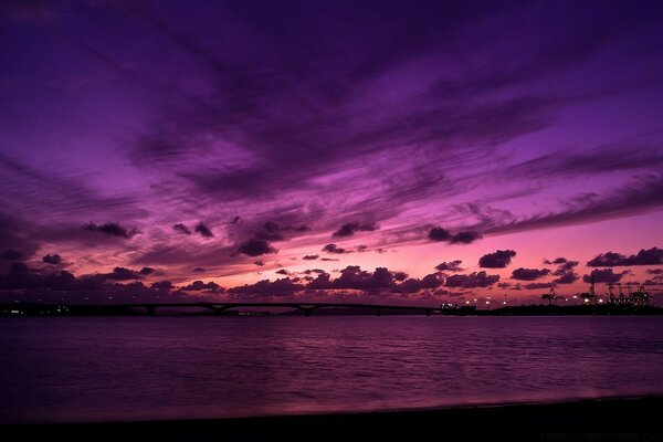 Hermosa puesta de sol sobre el agua de color púrpura