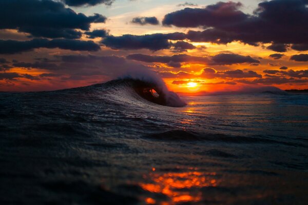 Vague sur fond de coucher de soleil rouge