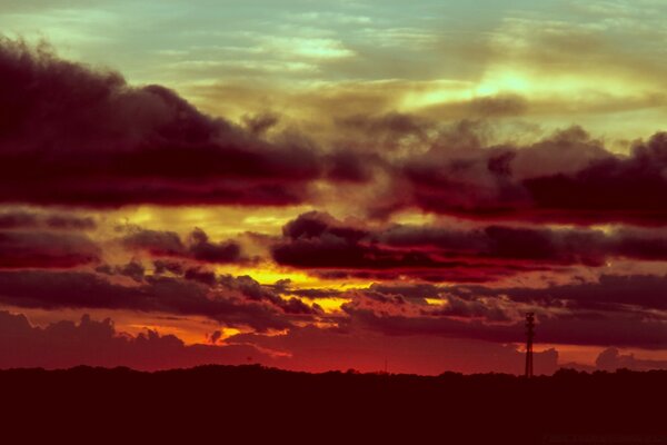 Puesta de sol roja entre densas nubes