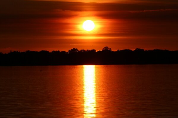 Der rote Sonnenuntergang spiegelt sich auf dem Wasser wider