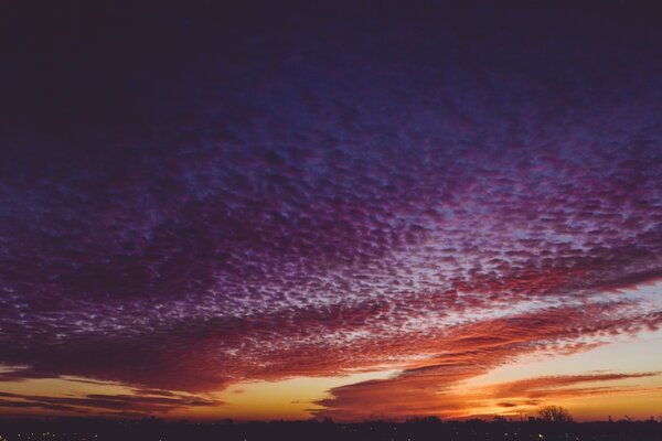 Рассыпчатые фиолетовые облака на всё небо переходящие в красно-оранжевый цвет