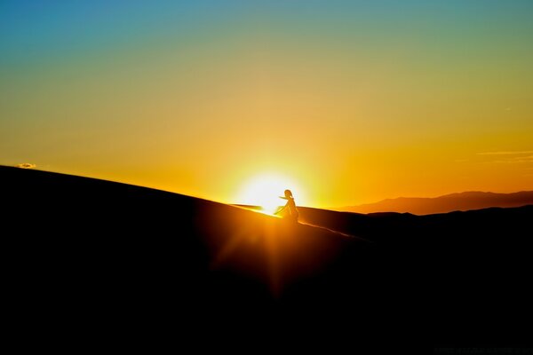 Chica en el fondo del amanecer sube una colina